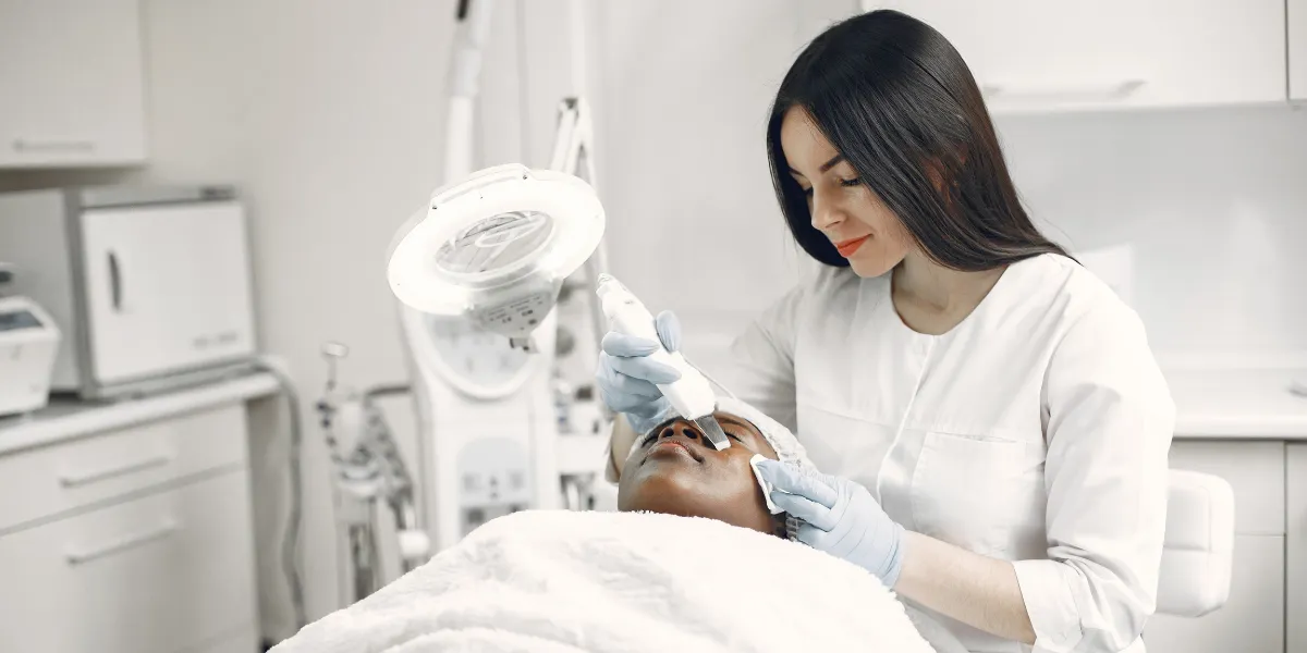A skilled practitioner performs a facial treatment, promoting wellness and skincare in a modern clinic.