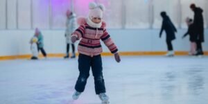 child outdoor ice skating bundled in winter clothes