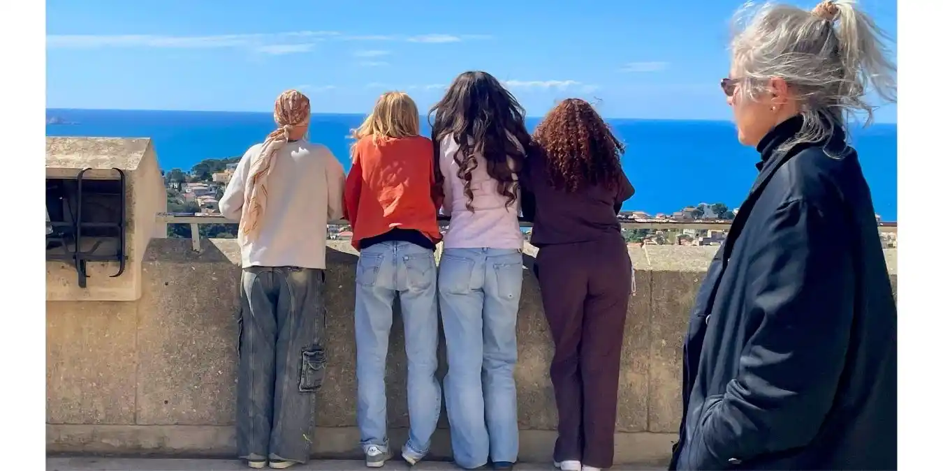 multi generations of women looking out to sea in the sunshine
